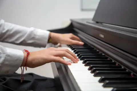 Müzik çalışmasında piyano çalan öğrencinin elleri
